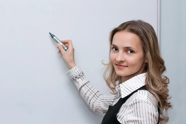 Meisje naast plankjes met markering in hand — Stockfoto