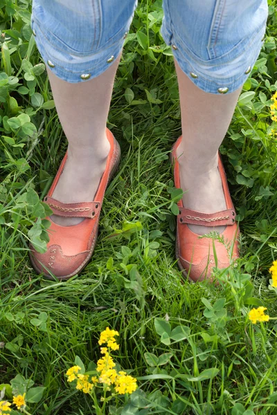 Gambe in mocassino arancione su erba verde — Foto Stock