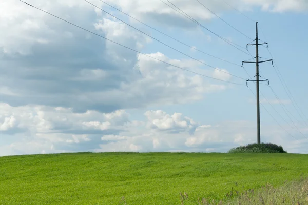 stock image High-tension poles on background clouds