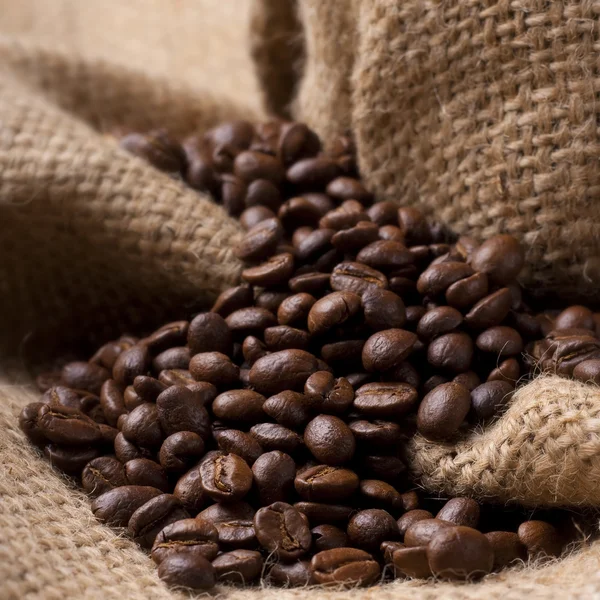 Coffee beans on burlap fabric — Stock Photo, Image