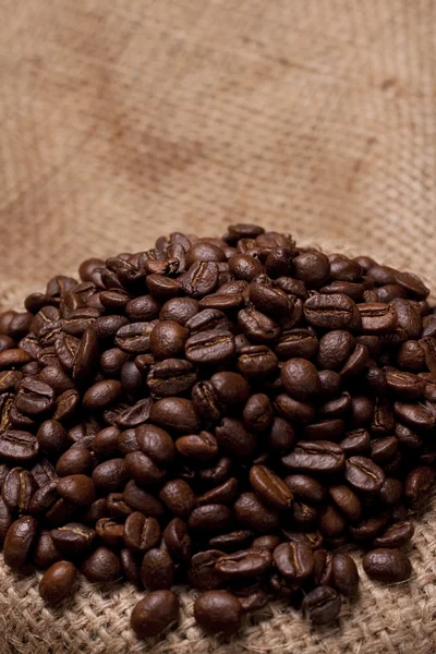 Koffie bonen met focus op jute stof — Stockfoto