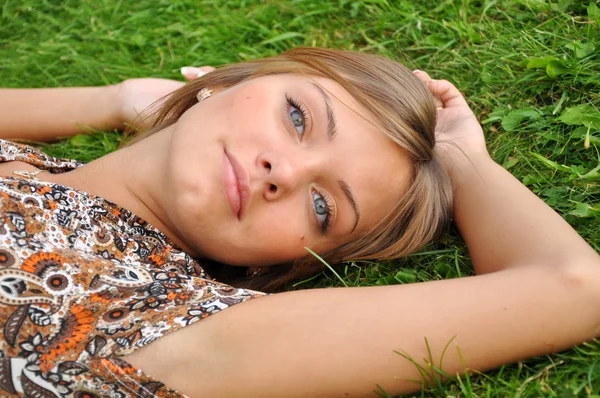 Young woman rests on a grass — Stock Photo, Image