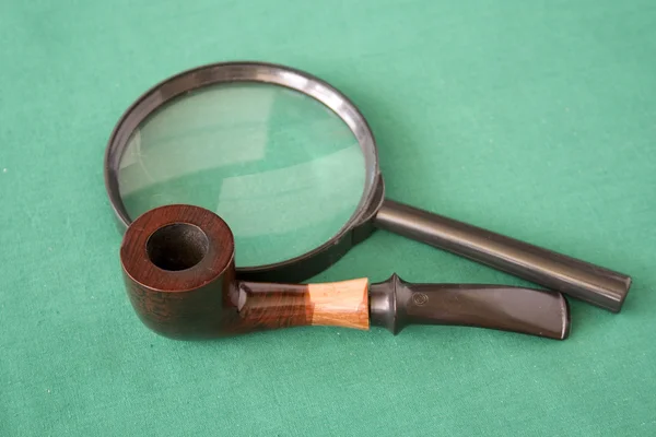 Magnifying glass and pipe — Stock Photo, Image