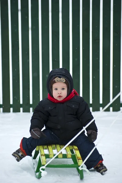 男孩坐在雪橇上 — 图库照片