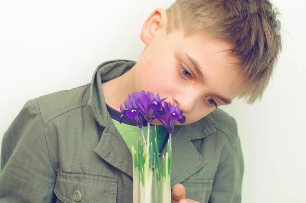 De jongen met blauwe iris bloemen — Stockfoto
