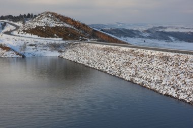 Mountain reservoir, dam and windy road clipart