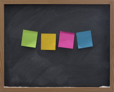 Blank, color sticky notes on blackboard clipart