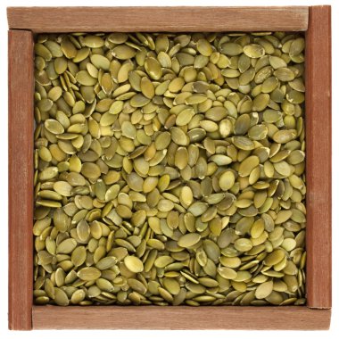 Pepitas (pumpkin seeds) in a wooden box clipart