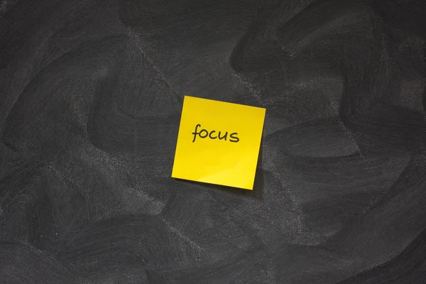 Focus op gele kleverige nota tegen schoolbord — Stockfoto