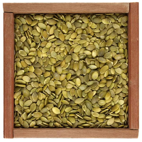 Pepitas (sementes de abóbora) em uma caixa de madeira — Fotografia de Stock