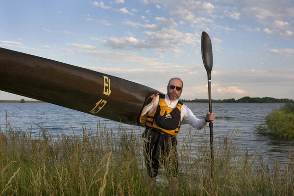 Paleta que lleva un kayak de carreras —  Fotos de Stock