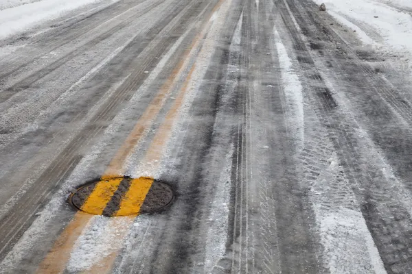 Estrada gelada escorregadia com linha amarela — Fotografia de Stock
