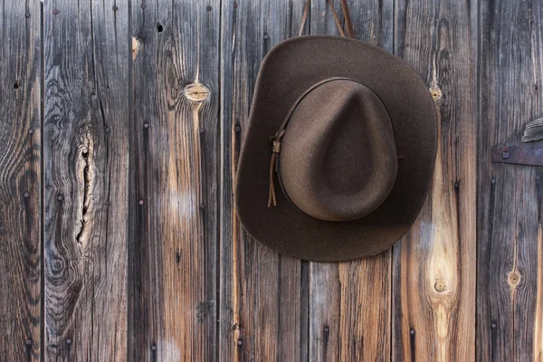 Chapéu de cowboy feltro na parede do celeiro — Fotografia de Stock