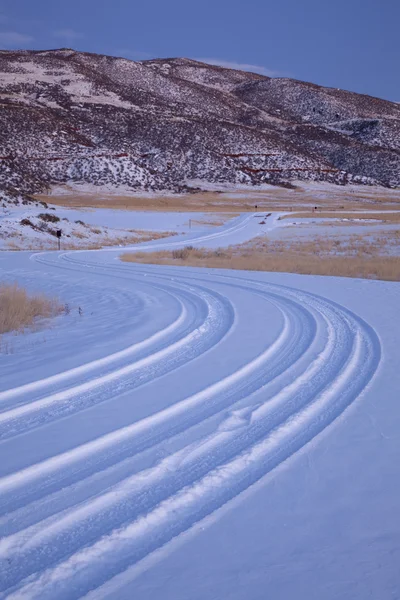 Ветреная сельская дорога, покрытая снегом — стоковое фото