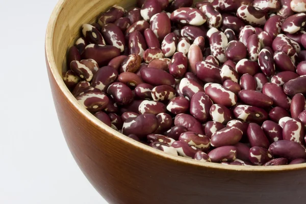 Wooden, round bowl of anasazi beans