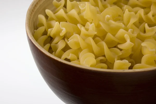 Houten bord ongekookt fusilli pasta — Stockfoto