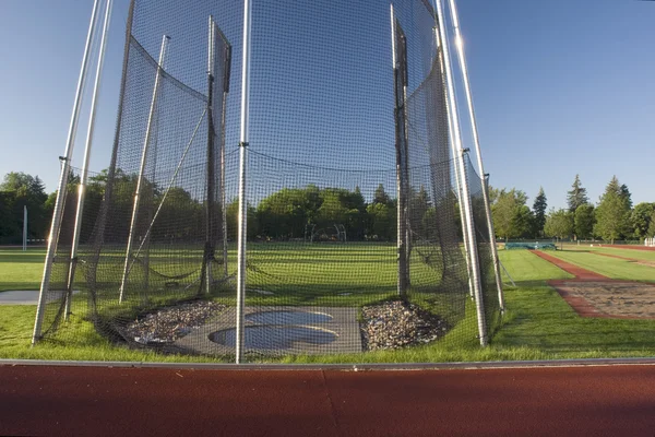 Campo de atletismo con una jaula de lanzamiento de martillo y larga — Foto de Stock