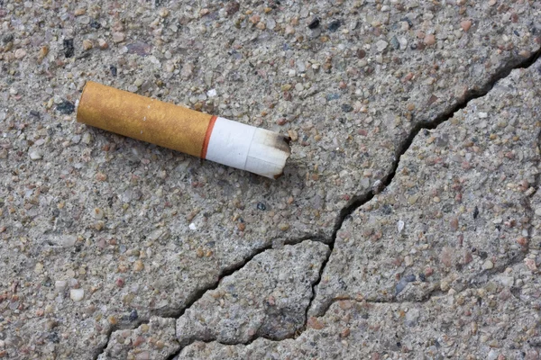 Colilla de cigarrillo en una acera — Foto de Stock
