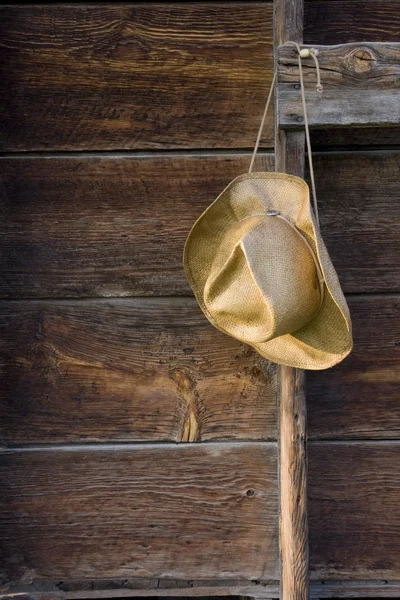 Chapéu de palha de vaqueiro contra madeira intemperizada — Fotografia de Stock