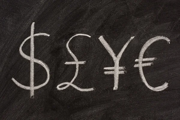 Symboly ze čtyř měn na tabuli — Stock fotografie