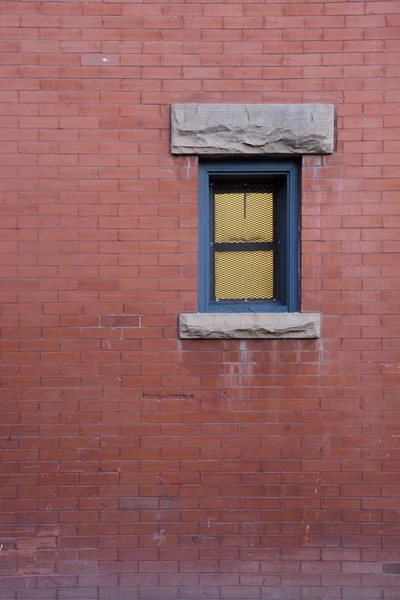 Parede de tijolo com uma pequena janela — Fotografia de Stock