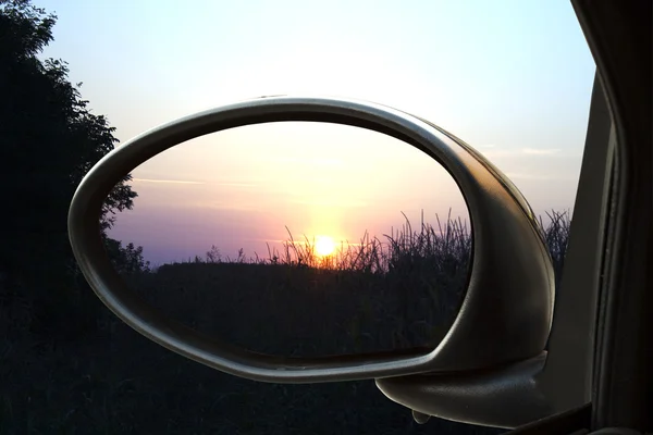 Solnedgång i rearviewmirror Stockfoto