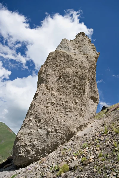 Ogromna skała przeciw błękitne niebo z chmurami — Zdjęcie stockowe