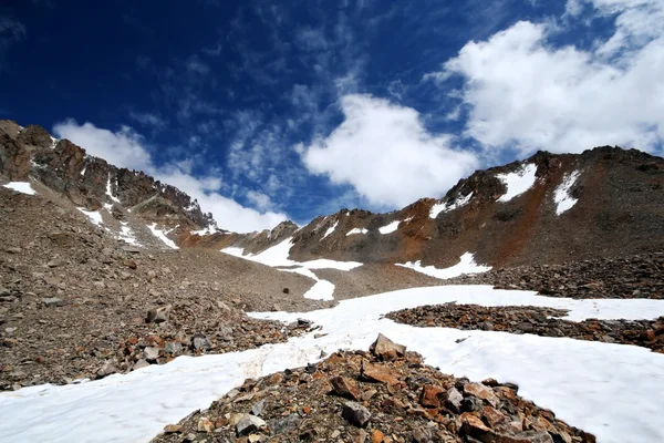 Skały, śnieg, niebo i chmury w górach — Zdjęcie stockowe