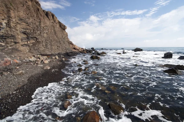 Costa del mar, espuma, piedras y guijarros — Foto de Stock