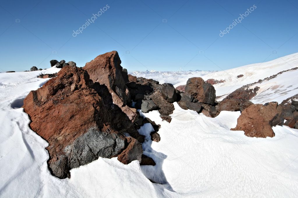 Rocks in snow against a clear blue sky