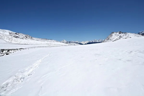 Powierzchni śniegu góry błękitne niebo — Zdjęcie stockowe