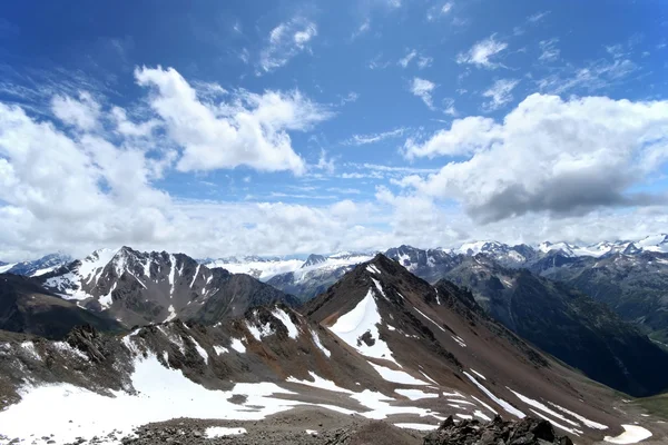 Rochas, neve, nuvens e céu nas montanhas do Cáucaso — Fotografia de Stock