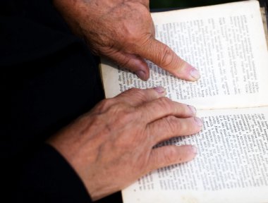 Yaşlı adamın elleri eski defterde.