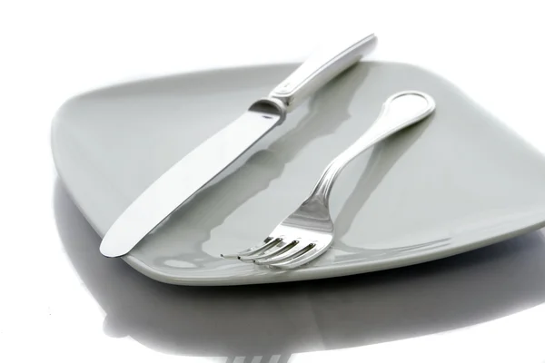 Вилка и нож на тарелке — стоковое фото