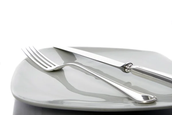Tenedor y cuchillo en un plato — Foto de Stock