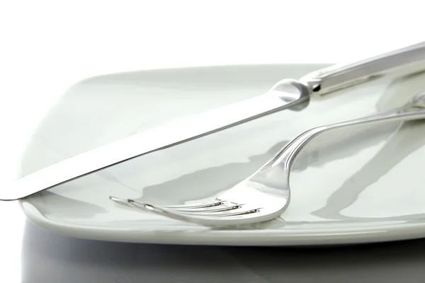 Tenedor y cuchillo en un plato —  Fotos de Stock