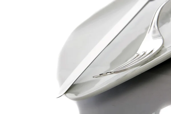 Tenedor y cuchillo en un plato —  Fotos de Stock