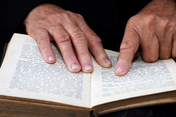 Руки старшого на старій книзі — стокове фото