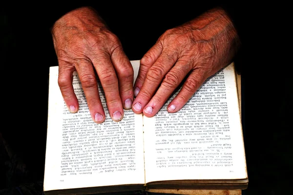 Starší ruce na staré knize — Stock fotografie