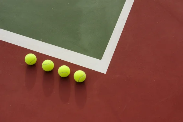 Чотири тенісні м'ячі на корті . — стокове фото