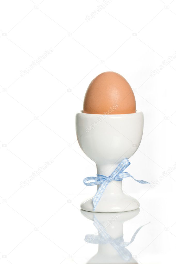 Egg and egg cup against white