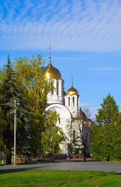 Orthodox church among turning trees — Stock Photo, Image