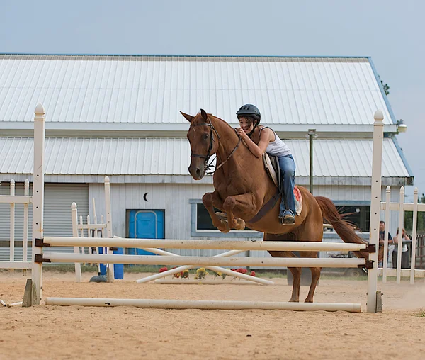 Athletic teen equestrian jumping a horse — Stock Photo, Image