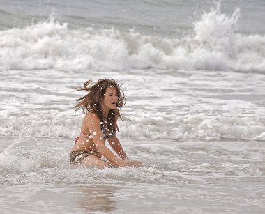 Athletic teen girl at the beach. clipart