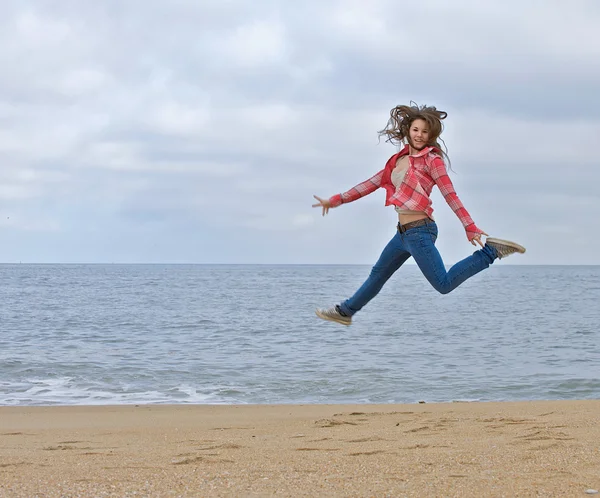 stock image Teen girl jumping excitedly on the beach