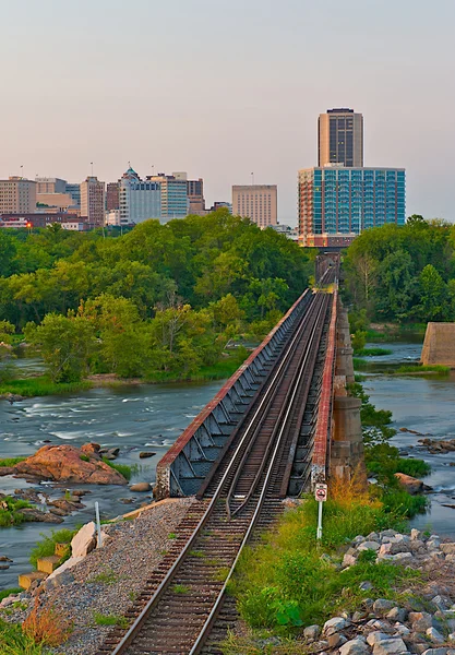 城市景观的列车跟踪在一条河. — 图库照片