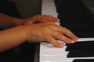 Child's hands playing piano clipart