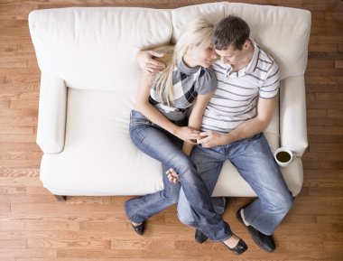 Young Couple Sitting on Love Seat clipart