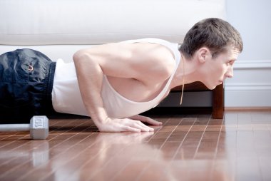 Man Doing Push-ups in Living Room clipart