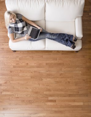 Overhead View of Woman on Couch With Laptop clipart